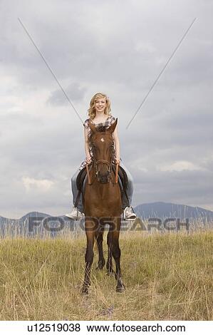 Young woman on a horse View Large Photo Image Stock Photo - Young woman on a horse. Fotosearch