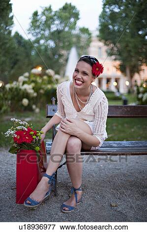 Stock Photo - Young woman on park bench. Fotosearch