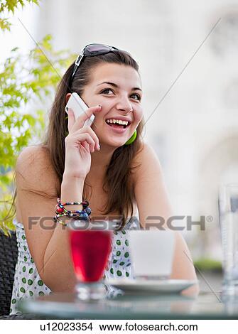 Young woman on phone in cafÈ View Large Photo Image Picture - Young woman on phone in cafÈ. Fotosearch