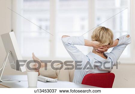 Young woman relaxing at desk View Large Photo Image Stock Photo - Young woman relaxing at desk. Fotosearch