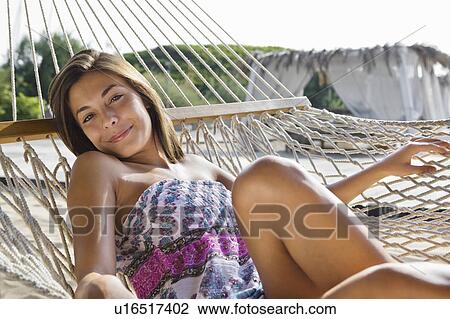 Stock Image - Young woman relaxing on hammock. Fotosearch