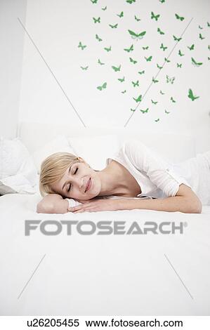Young woman resting on bed smiling View Large Photo Image Stock Photography - Young woman resting on bed smiling. Fotosearch
