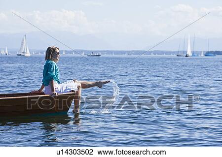 Young woman sitting on a boat View Large Photo Image Stock Image - Young woman sitting on a boat. Fotosearch