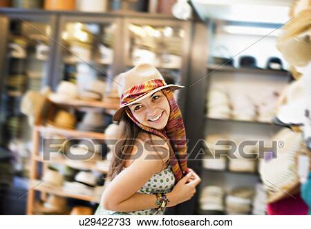 Young woman trying on hat View Large Photo Image Stock Image - Young woman trying on hat. Fotosearch