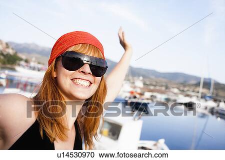 Young woman waving to camera View Large Photo Image Stock Image - Young woman waving to camera. Fotosearch
