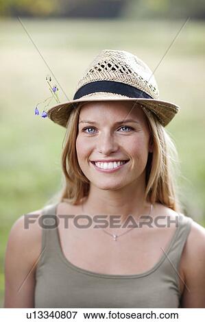 Young woman wearing hat with flowers View Large Photo Image Stock Photo - Young woman wearing hat with flowers. Fotosearch