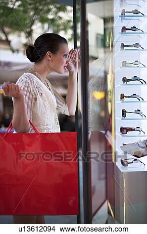 Picture - Young woman window shopping. Fotosearch