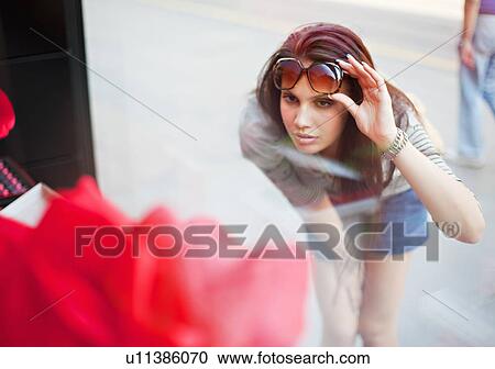 Stock Image - Young woman window shopping. Fotosearch