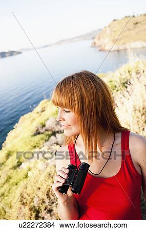 Picture - Young woman with binoculars. Fotosearch