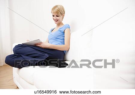Young woman writing, sketching on sofa View Large Photo Image Stock Photograph - Young woman writing, sketching on sofa. Fotosearch