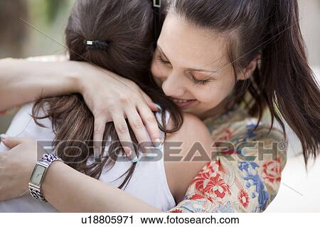Stock Image - Young women hugging. Fotosearch