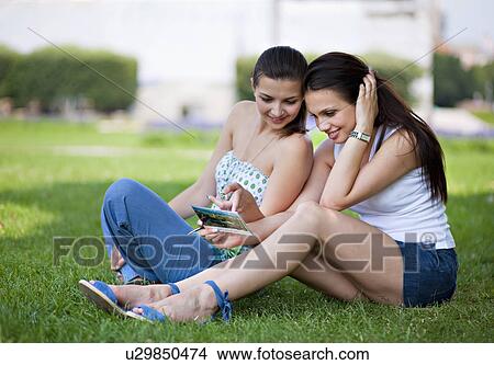 Young women looking at postcard View Large Photo Image Picture - Young women looking at postcard. Fotosearch