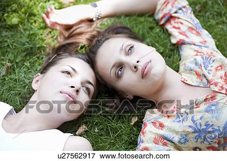Young women lying in grass View Large Photo Image Stock Photo - Young women lying in grass. Fotosearch