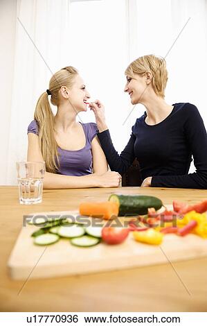 Stock Photograph - Young Women Preparing Food, eating. Fotosearch