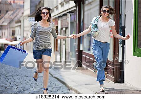 Young women running along street View Large Photo Image Picture - Young women running along street. Fotosearch
