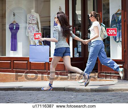 Young women running along street View Large Photo Image Stock Photo - Young women running along street. Fotosearch