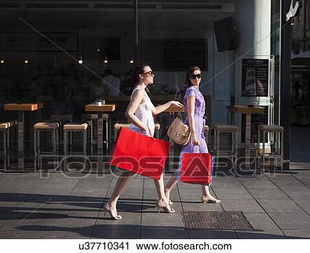 Stock Image - Young women shopping. Fotosearch