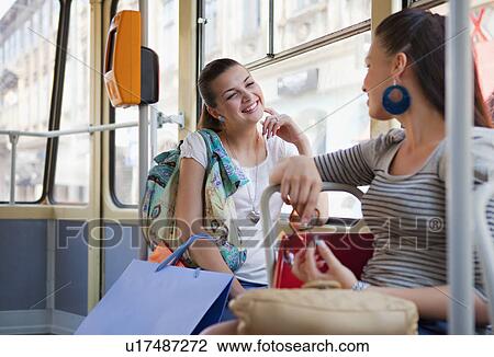 Young women talking in tram train View Large Photo Image Stock Image - Young women talking in tram train. Fotosearch