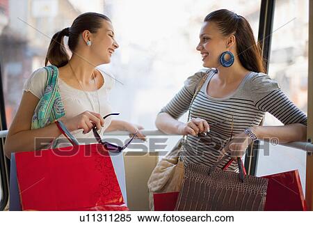 Young women talking in tram train View Large Photo Image Stock Photography - Young women talking in tram train. Fotosearch