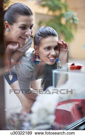 Young women window shopping View Large Photo Image Stock Photo - Young women window shopping. Fotosearch