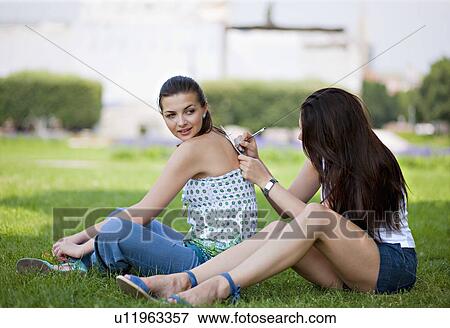 Stock Photo - Young women writing postcard. Fotosearch