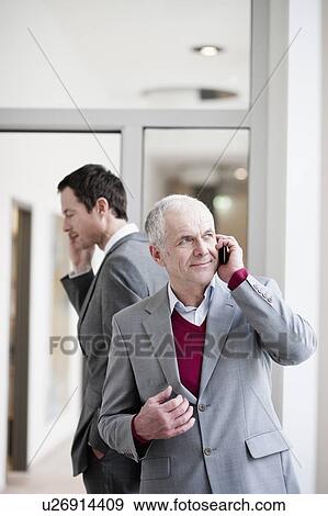 Stock Photo - 2 businessman speaking on cellphones. Fotosearch