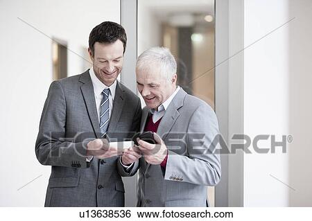 2 businessmen checking handhelds View Large Photo Image Stock Photograph - 2 businessmen checking handhelds. Fotosearch