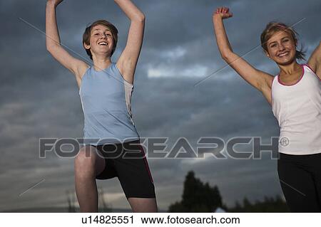 Stock Image - 2 female athletes celebrating. Fotosearch