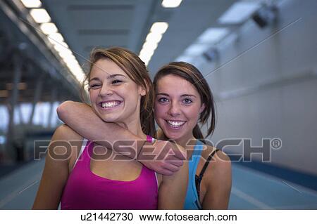 Stock Image - 2 female athletes embracing. Fotosearch