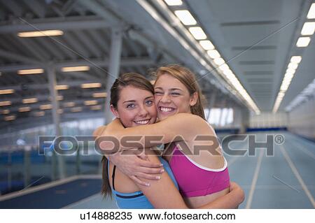 Stock Photography - 2 female athletes embracing. Fotosearch