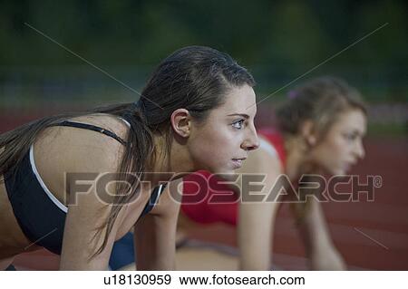 Stock Photo - 2 female athletes in starting blocks. Fotosearch