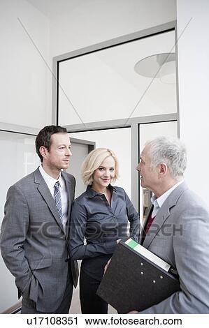 Stock Image - 3 business people meeting. Fotosearch