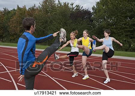 Stock Image - 3 female athletes and trainer. Fotosearch