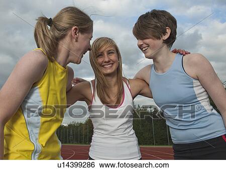 Stock Photograph - 3 female athletes embracing. Fotosearch