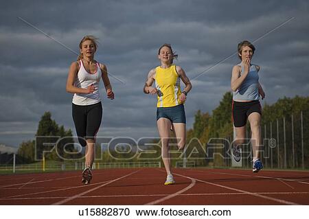 Stock Image - 3 female athletes racing towards camera. Fotosearch