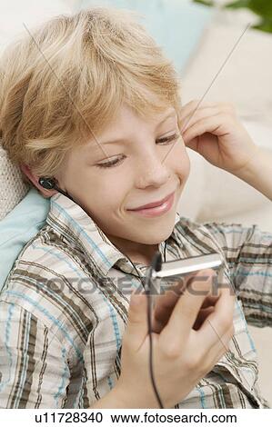 A boy listening to an MP3 player View Large Photo Image Stock Image - A boy listening to an MP3 player. Fotosearch