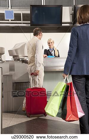 Stock Image - A couple checking in with shopping bags. Fotosearch