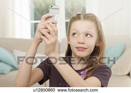 A girl taking pictures on her mobile View Large Photo Image Stock Image - A girl taking pictures on her mobile. Fotosearch
