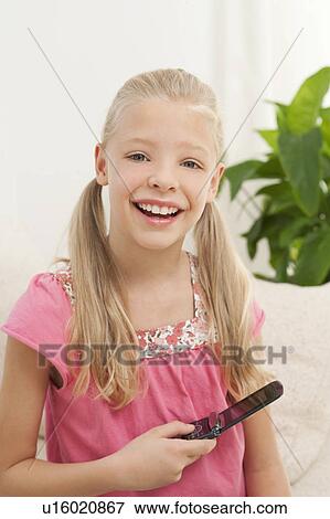 Stock Photo - A young girl holding a mobile phone. Fotosearch