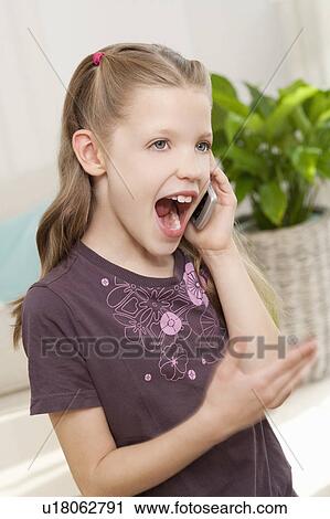 Stock Image - A young girl on her mobile phone. Fotosearch