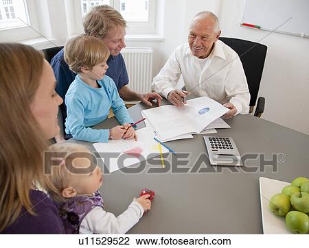 Stock Image - Advisor discussing papers with a family. Fotosearch