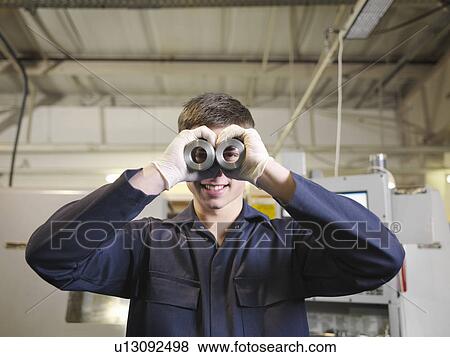 Stock Photo - Apprentice Looking Through Cylinders. Fotosearch