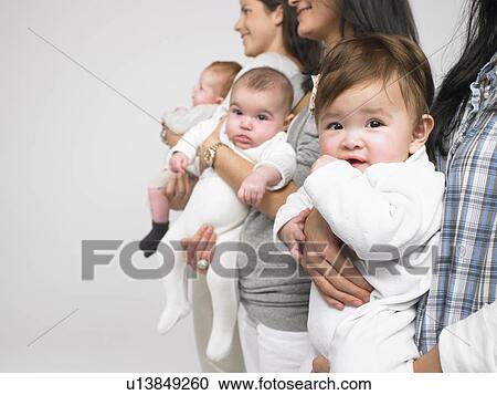 Babies in mothers' arms View Large Photo Image Stock Image - Babies in mothers' arms. Fotosearch