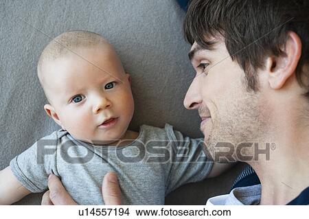 Baby boy with Dad looking to camera View Large Photo Image Picture - Baby boy with Dad looking to camera. Fotosearch