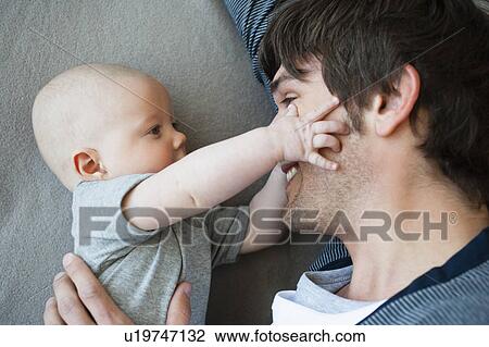 Baby touching fathers face View Large Photo Image Stock Image - Baby touching fathers face. Fotosearch