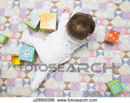 Baby with cubes on quilt View Large Photo Image Stock Photograph - Baby with cubes on quilt. Fotosearch