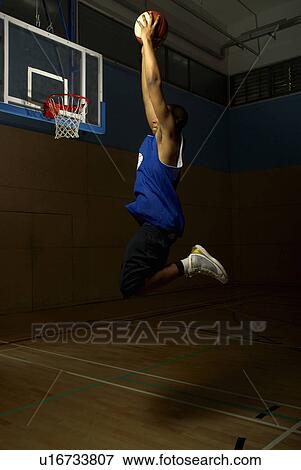Stock Photo - Basketball player jumping to hoop. Fotosearch