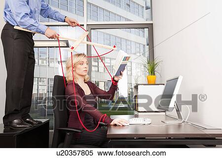 Stock Photography - Boss coordinating employee at desktop. Fotosearch