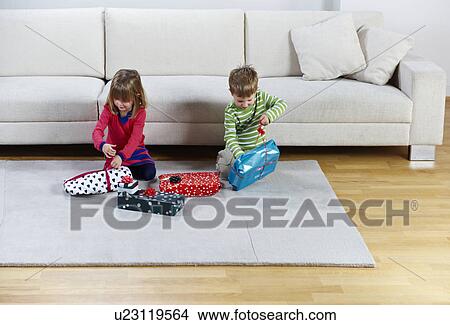 Boy and girl opening presents View Large Photo Image Picture - Boy and girl opening presents. Fotosearch