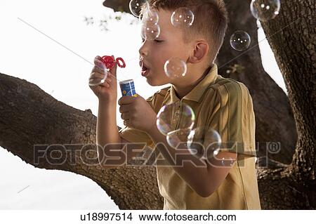 Picture - Boy blowing soap bubbles. Fotosearch